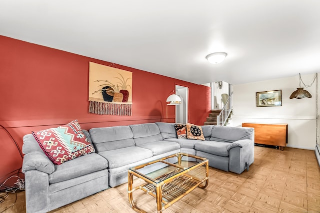 living area featuring stairway and baseboards