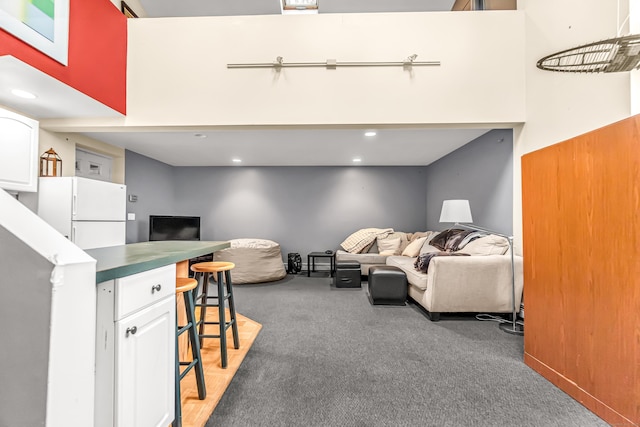 living room featuring light carpet and a towering ceiling