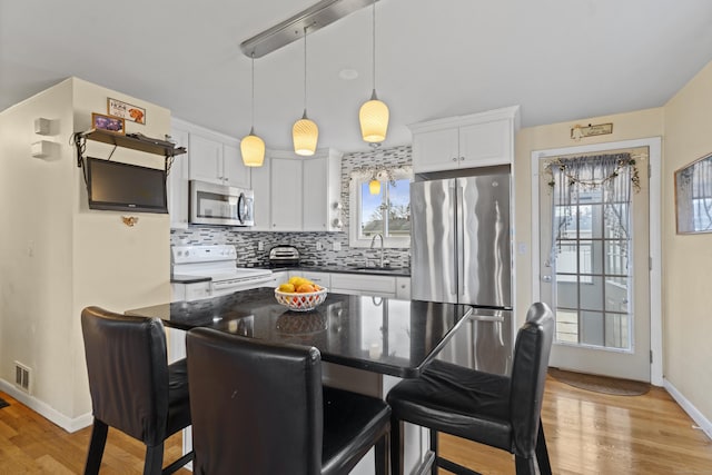 kitchen with stainless steel appliances, a breakfast bar, a sink, and decorative backsplash