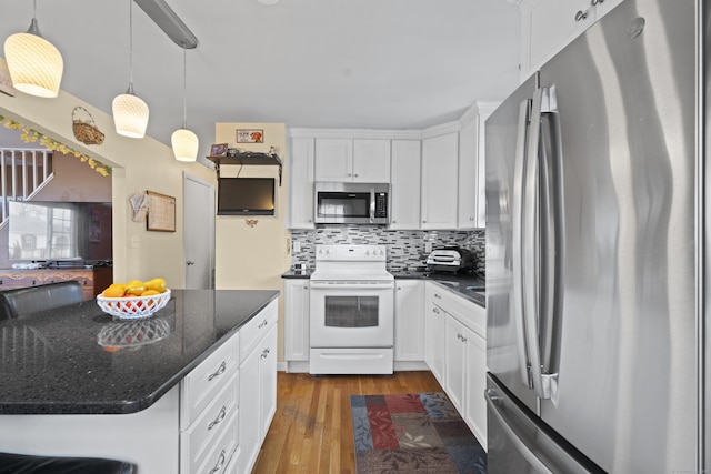 kitchen featuring dark wood-style flooring, white cabinets, hanging light fixtures, appliances with stainless steel finishes, and tasteful backsplash