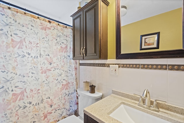 full bath with tile walls, toilet, curtained shower, vanity, and backsplash