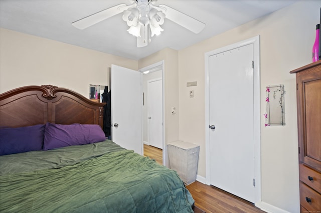 bedroom with ceiling fan, wood finished floors, and baseboards