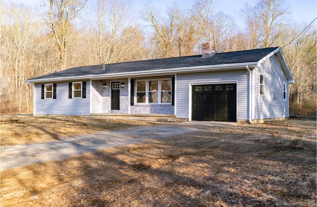 single story home with an attached garage, driveway, and a chimney