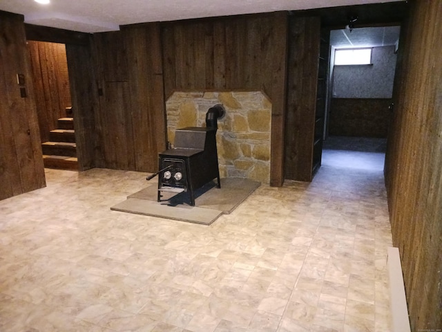 153 Bozrah St, Bozrah, CT 06334 - basement featuring wood walls, light flooring, stairway, and a wood stove