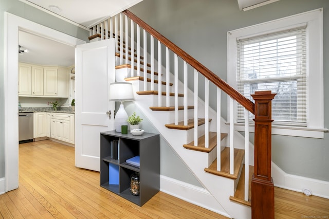 stairs featuring wood finished floors and baseboards