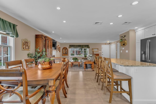 dining space with light wood-type flooring, visible vents, crown molding, and recessed lighting