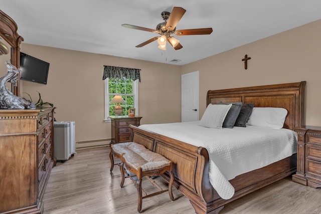 bedroom with light wood finished floors, a baseboard radiator, visible vents, and a ceiling fan