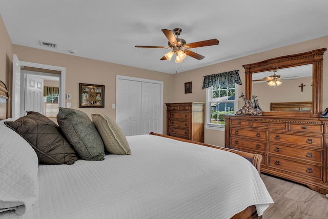 bedroom featuring a ceiling fan, light wood-type flooring, a closet, and visible vents