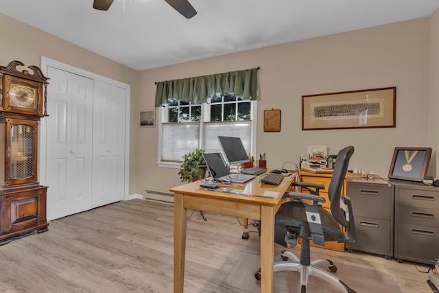 office area featuring a baseboard radiator, a ceiling fan, and light wood-style floors