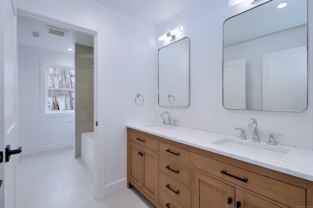 bathroom featuring double vanity, visible vents, baseboards, and a sink