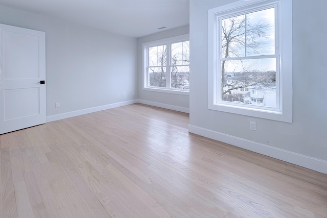 unfurnished room featuring light wood finished floors and baseboards