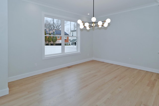 empty room featuring baseboards, wood finished floors, and an inviting chandelier