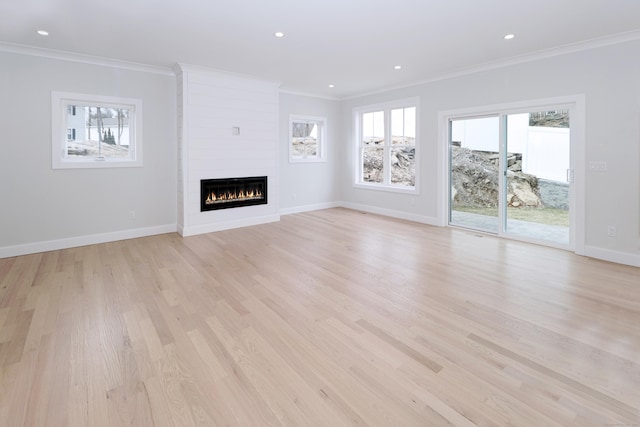 unfurnished living room featuring baseboards, recessed lighting, a fireplace, and crown molding