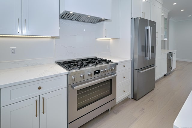 kitchen featuring stainless steel appliances, white cabinetry, light wood-style floors, backsplash, and custom exhaust hood