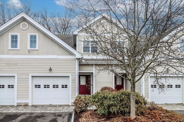 view of front of house featuring an attached garage and a shingled roof