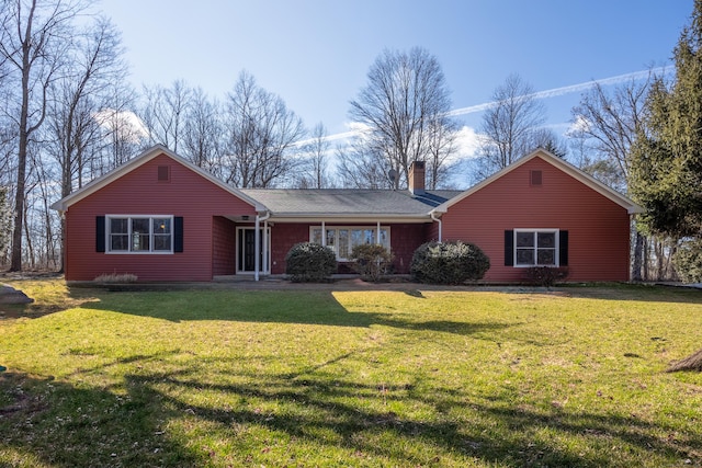 ranch-style home with a front yard and a chimney