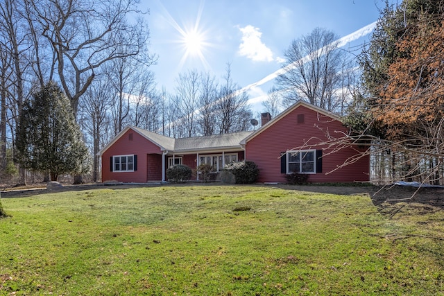 view of front of property with a chimney and a front lawn