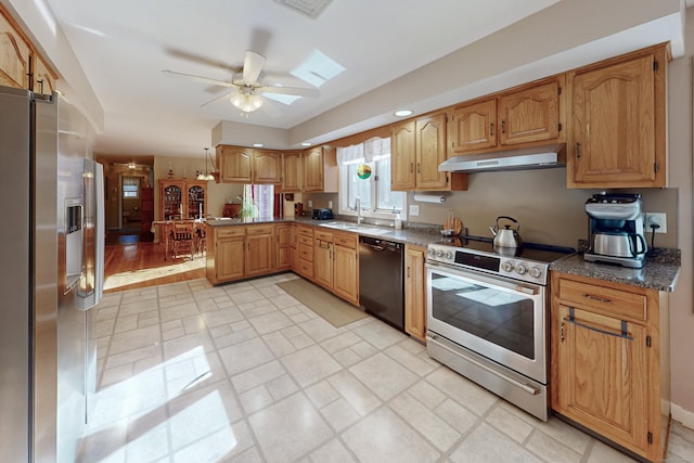 kitchen featuring a ceiling fan, appliances with stainless steel finishes, a peninsula, under cabinet range hood, and a sink