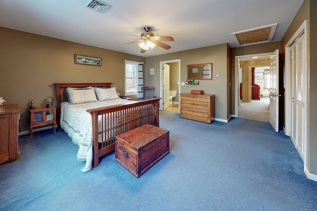 carpeted bedroom with a closet, visible vents, ensuite bathroom, attic access, and ceiling fan