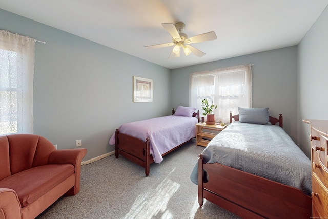 carpeted bedroom with ceiling fan and baseboards