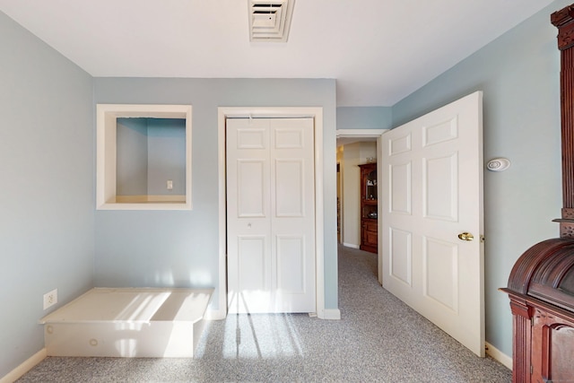 carpeted bedroom featuring a closet, visible vents, and baseboards