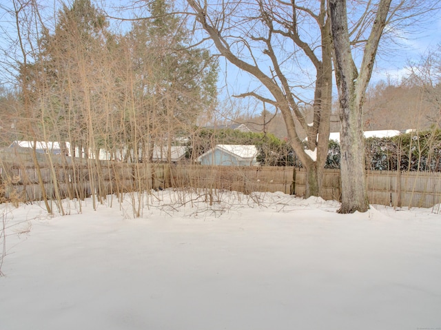 yard covered in snow featuring fence