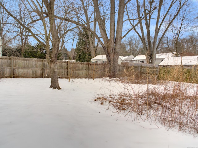 yard covered in snow with fence