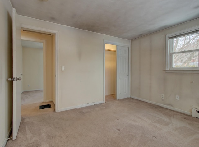 unfurnished bedroom with a closet, carpet flooring, visible vents, and baseboards