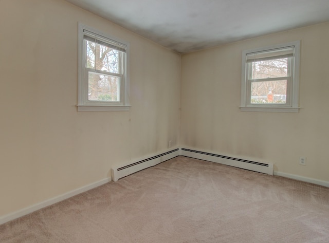 carpeted spare room featuring plenty of natural light and baseboards