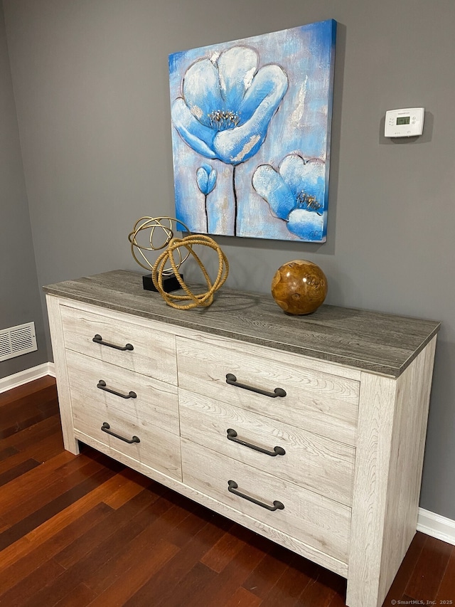 room details featuring visible vents, baseboards, and wood finished floors