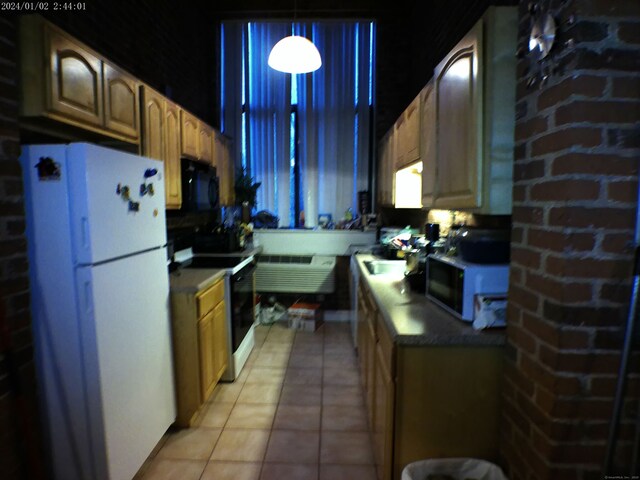 390 Charles St Apt 216, Bridgeport, CT 06606 - kitchen featuring black microwave, light tile patterned flooring, electric range, hanging light fixtures, and freestanding refrigerator