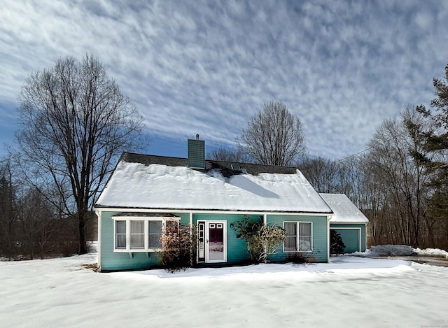 view of front facade featuring an attached garage and a chimney