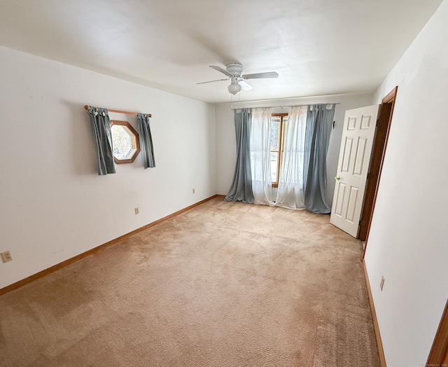 unfurnished room featuring plenty of natural light, light colored carpet, and baseboards