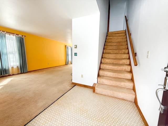 stairs featuring baseboards and carpet floors