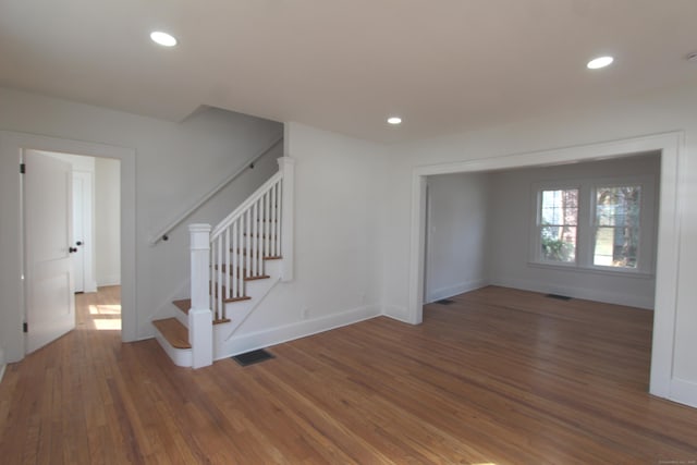 interior space featuring baseboards, stairway, wood finished floors, and recessed lighting