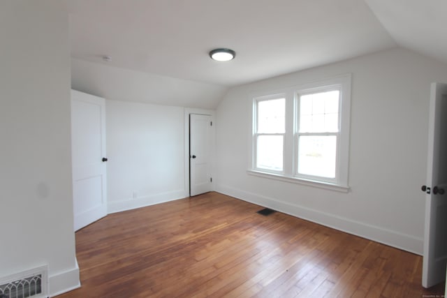 bonus room with lofted ceiling, baseboards, visible vents, and hardwood / wood-style floors