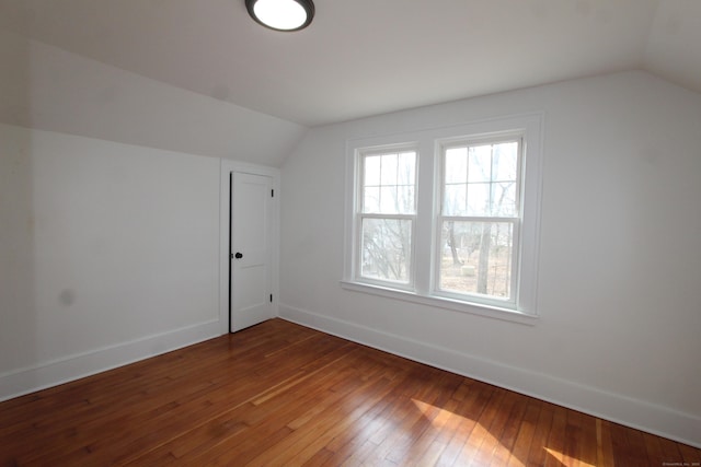 bonus room with lofted ceiling, wood-type flooring, and baseboards