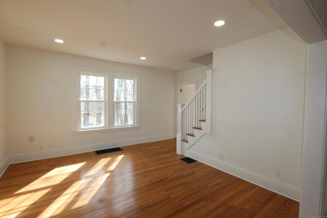 empty room with stairs, visible vents, wood finished floors, and recessed lighting