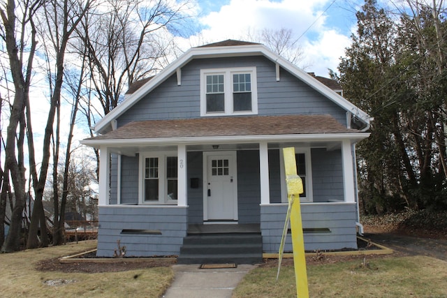 bungalow with a porch and roof with shingles