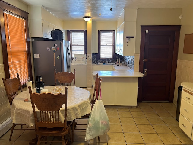 dining space featuring wainscoting, tile walls, and light tile patterned flooring