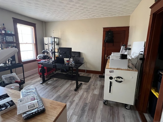 office with a textured ceiling, baseboards, and wood finished floors