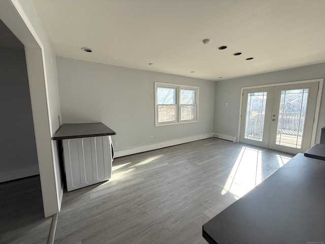 interior space featuring baseboards, a baseboard radiator, wood finished floors, french doors, and recessed lighting