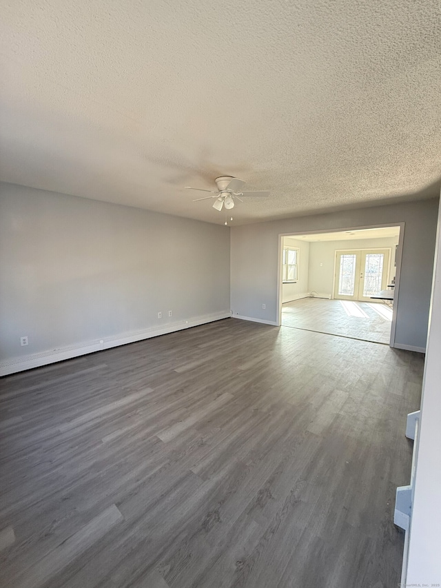 spare room with dark wood-style floors, ceiling fan, a textured ceiling, and baseboards