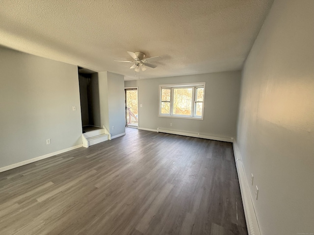 unfurnished room with baseboards, dark wood finished floors, ceiling fan, a baseboard radiator, and a textured ceiling