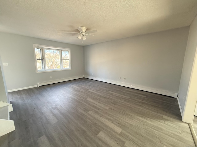 spare room featuring ceiling fan, a textured ceiling, baseboards, and wood finished floors