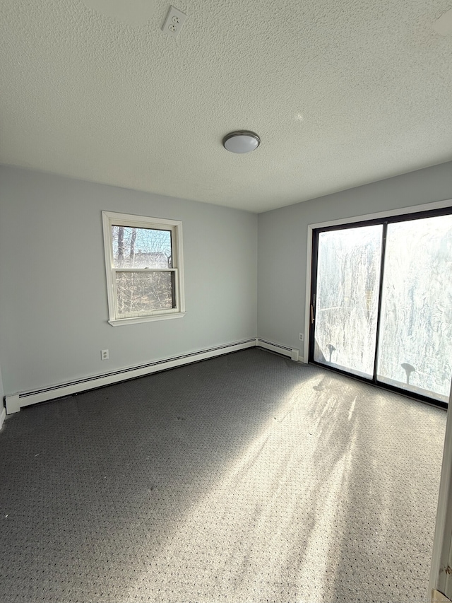 spare room featuring a textured ceiling and baseboard heating