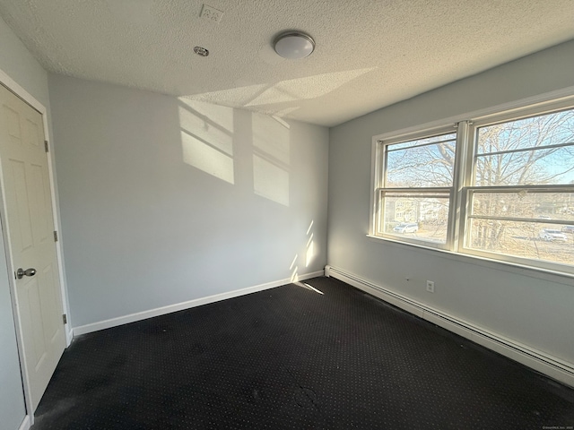 unfurnished room featuring a baseboard radiator, baseboards, dark carpet, and a textured ceiling