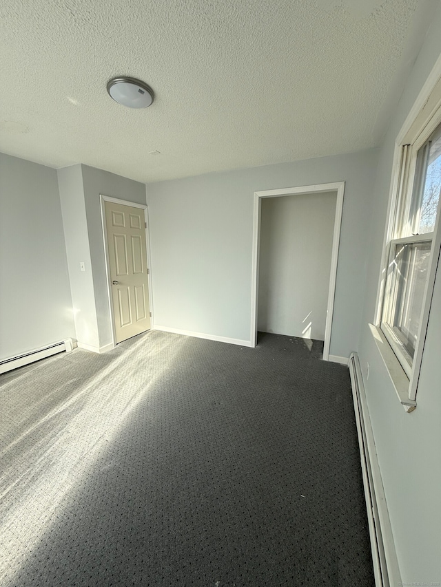 unfurnished room featuring a baseboard heating unit, baseboard heating, and baseboards