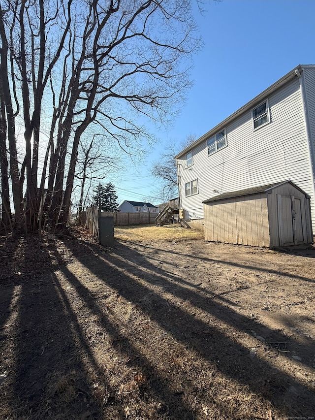 view of property exterior featuring an outdoor structure, a storage shed, and fence