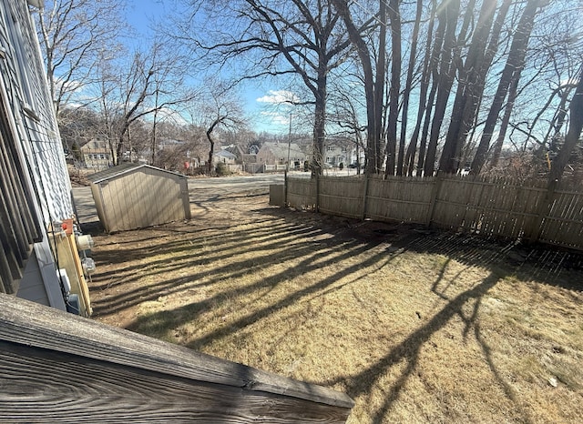 view of yard with a storage unit, an outdoor structure, and fence